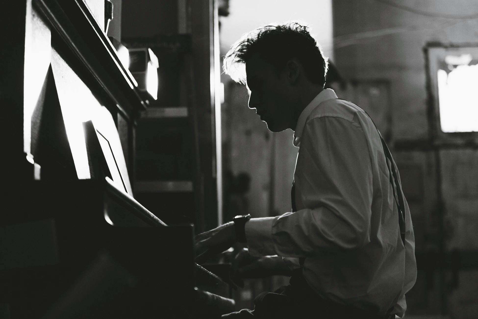 Man in white shirt is playing piano