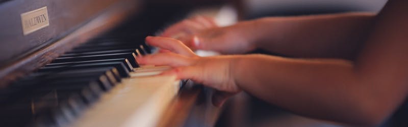 Bambino che suona su un vecchio pianoforte