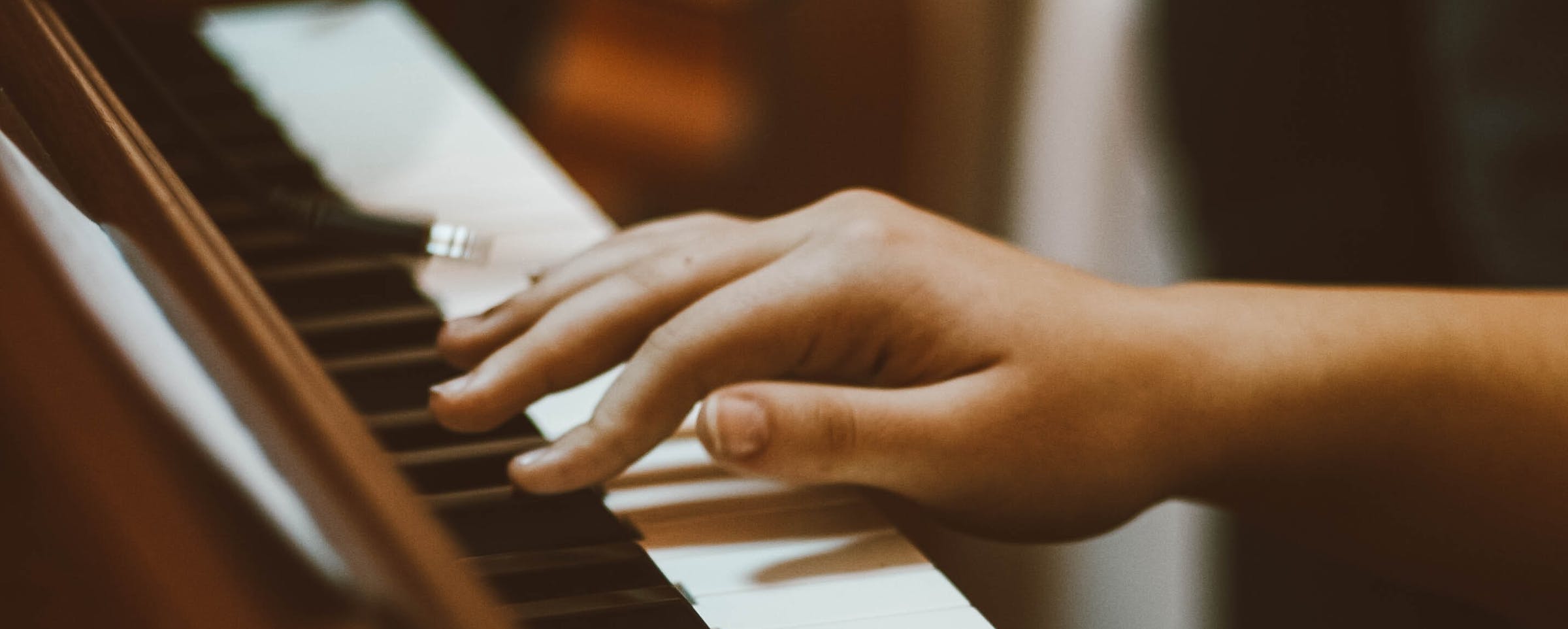 Hand on a brown piano