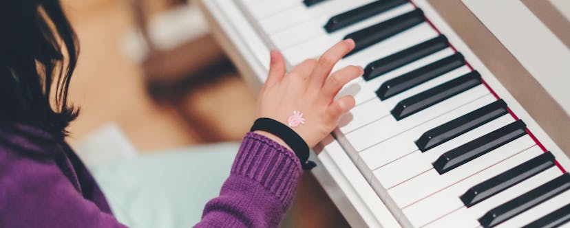 Child playing on a white piano